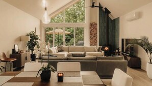 Una sala de estar moderna con un ventanal grande, una chimenea y un sofá.