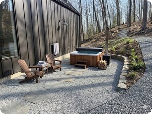 A wooden deck with Adirondack chairs, a hot tub, and a stone pathway. - 3-bedroom house in peaceful Callicoon perfect for relaxing getaways (Callicoon)
