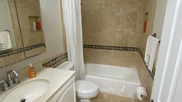 Un baño con lavabo, inodoro, bañera y cortina de ducha.