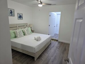 A bedroom with a bed, pillows, a ceiling fan, and a door leading to another room. - 3 Minutes to Anna Maria Island. Boat, RV & Jet Ski Parking + Large Private Yard (Bradenton)