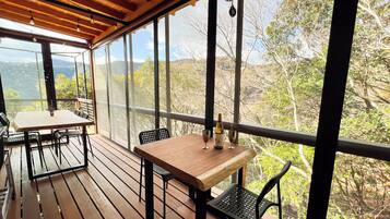 An outdoor patio with wooden flooring, metal chairs, and a table.