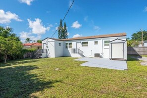 A single-story house with a front porch, a garage, and a small backyard. - 3BR/2BA - King Bed - Short drive to Downtown, Northwood, PBI Airport & Beaches (West Palm Beach)