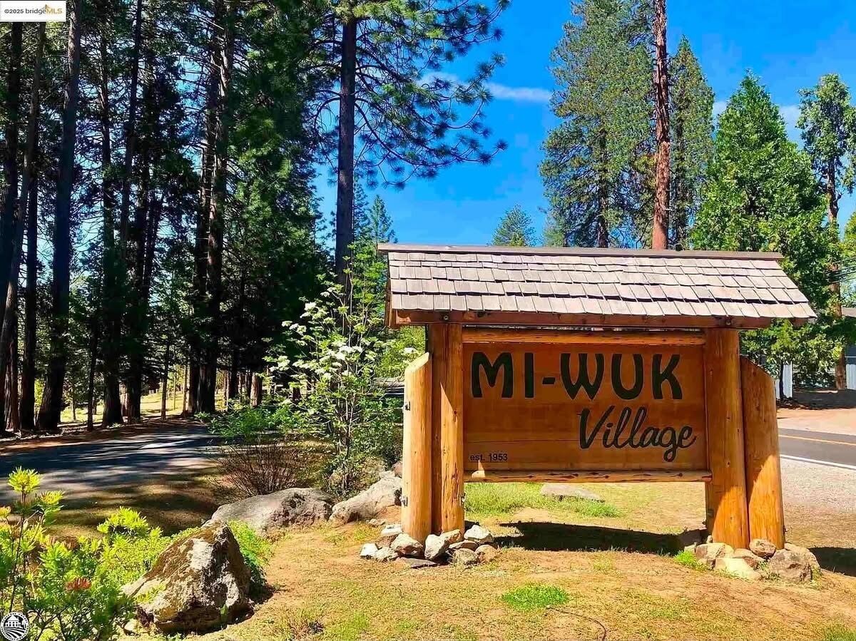 A wooden sign with the text 'MI-WUK Village' and 'EST. 1953' indicating a historical establishment.