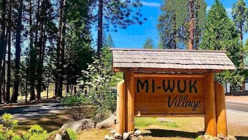 A wooden sign with the text 'MI-WUK Village' and 'EST. 1953' indicating a historical establishment.