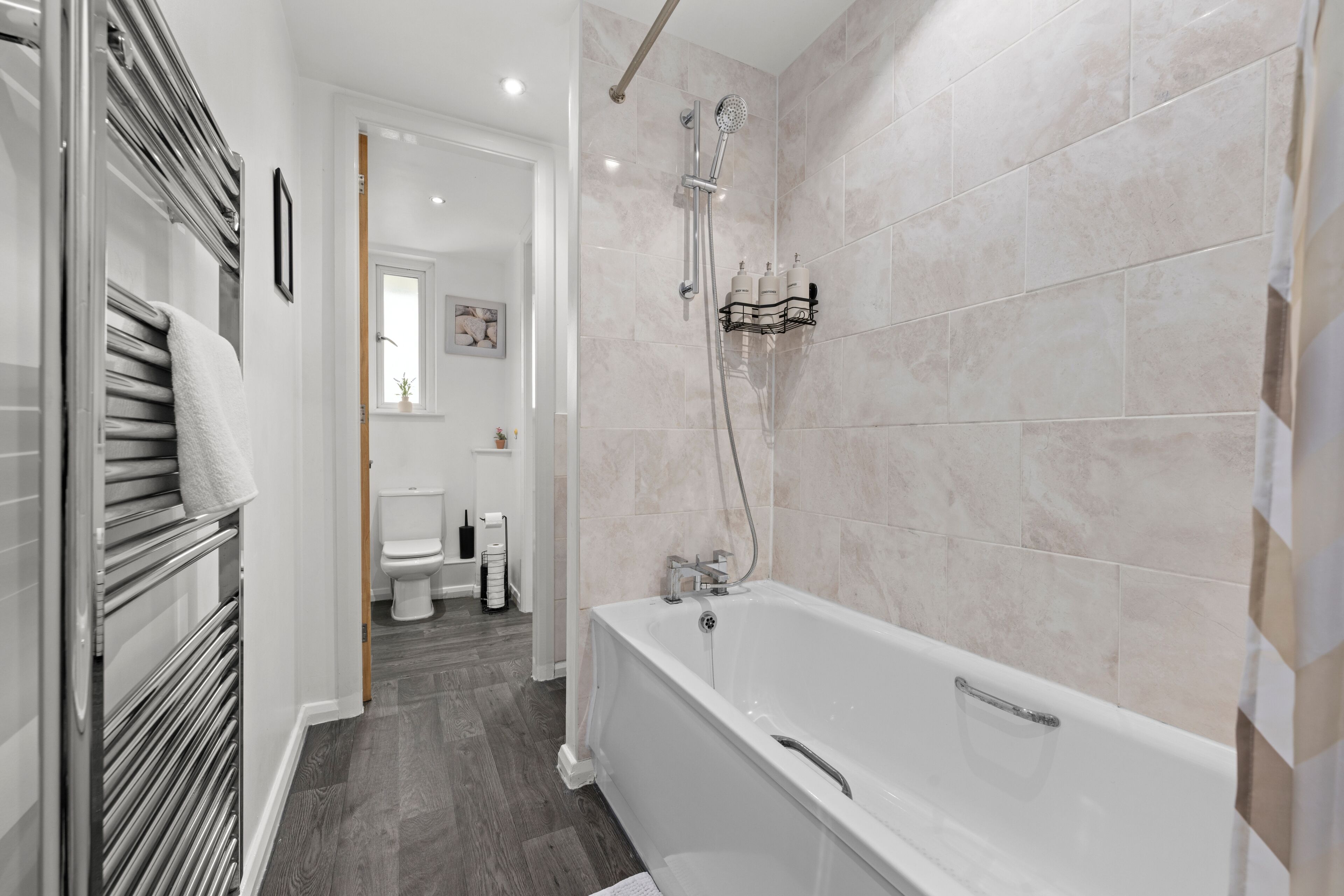 Ein modernes Badezimmer mit Badewanne, Dusche und Toilette.