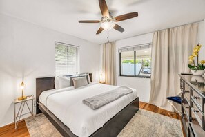 A bedroom with a bed, a ceiling fan, a nightstand, a dresser, a window with curtains, and a view of the outside. - Amazing property next to Las Olas Boulevard (5 min) (Fort Lauderdale)