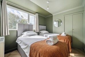 A hotel room with two beds, a round mirror, and a view of the outdoors. - 1 Bedroom Apartments Sleeps 3 - Balcony - Pets Ok (St. Ives)