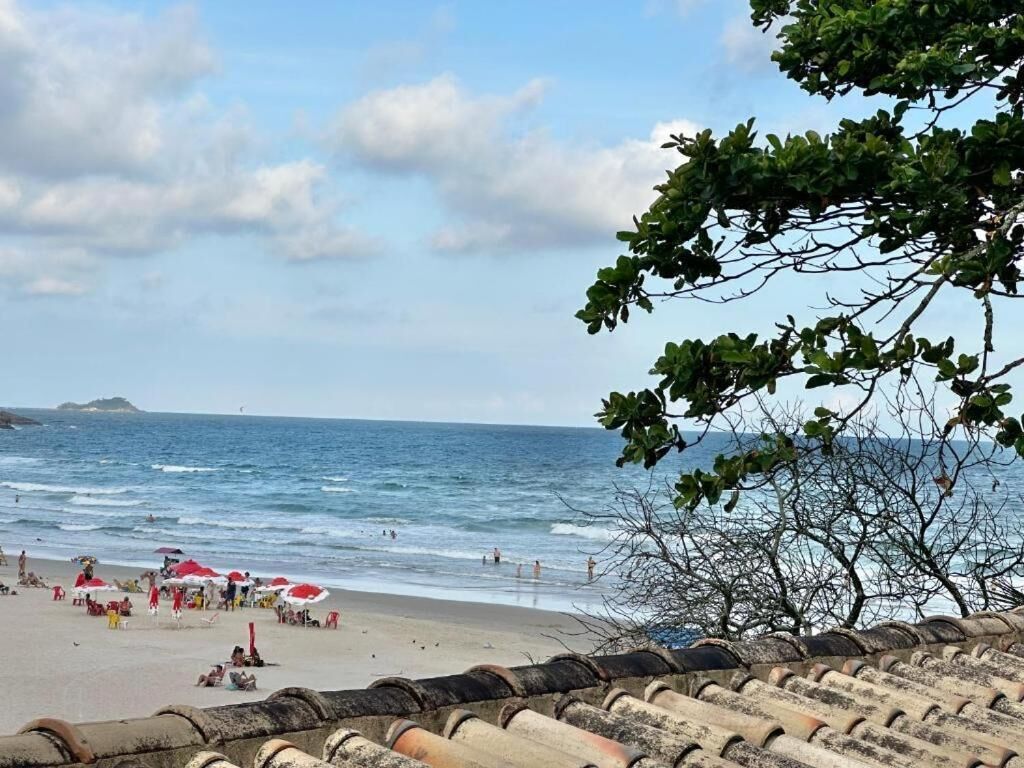 Una platja amb gent, ombrel·les i vista al mar.
