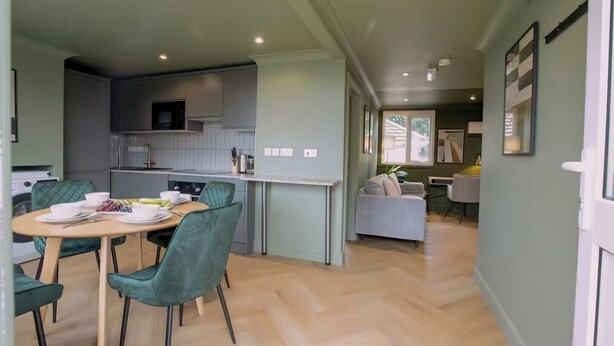 A modern kitchen with a dining area, a sofa, and a TV. - 1 Bedroom Apartment Sleeps 2 - Pets Welcome (St. Ives)