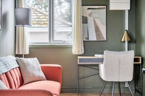 A room with a sofa, a desk, and a chair. - 1 Bedroom Apartment Sleeps 2 - Pets Welcome (St. Ives)