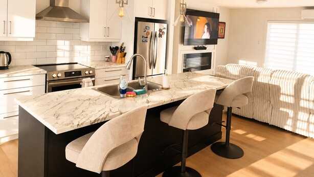 A modern kitchen with a marble countertop, stainless steel appliances, and a built-in TV. - The Pearl of Dieppe (Dieppe)