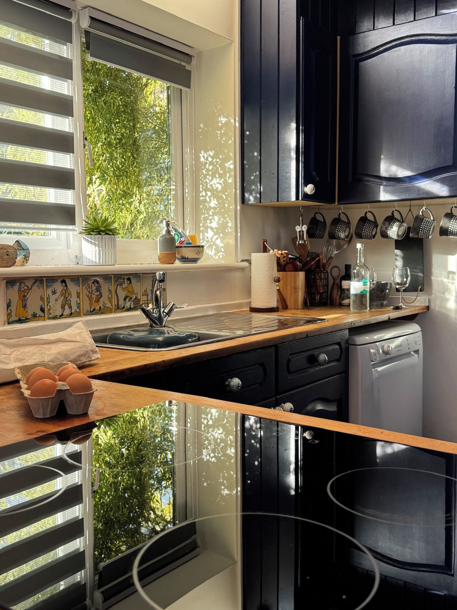 Una cucina con finestra, lavello, pensili e piano di lavoro.