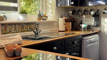 Una cucina con finestra, lavello, pensili e piano di lavoro.