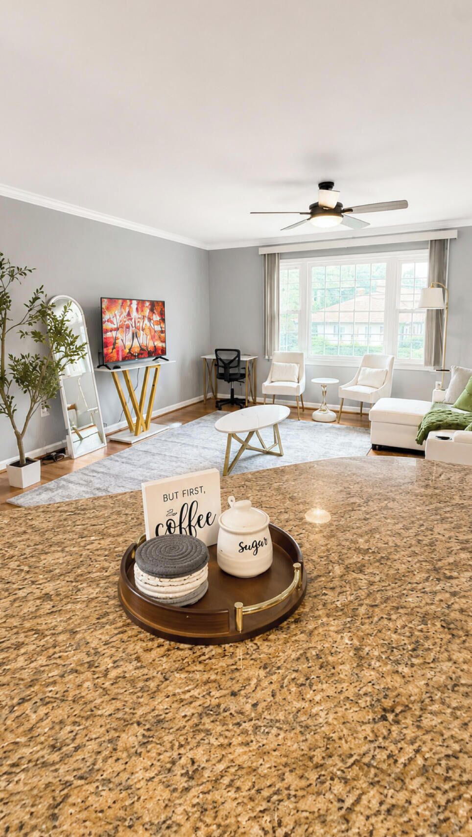 A modern living room with a television, seating area, and a coffee table with cookies and sugar.