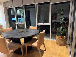 Una zona de dinar moderna amb una taula rodona, cadires beix i una planta decorativa.