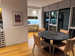 A modern dining area with a round table, chairs, and a decorative centerpiece. - 2B2B Executive Residence in Barton, 7-9 min walk to PH, M-Oval & Lake BG (Barton)