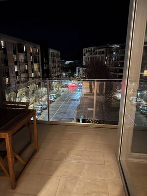 A balcony with a view of a parking lot and buildings at night. - 2B2B Executive Residence in Barton, 7-9 min walk to PH, M-Oval & Lake BG (Barton)