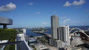 A high-rise building with a view of a waterfront and a bridge. - Luxurious 1BR condo in prime Location (Miami)
