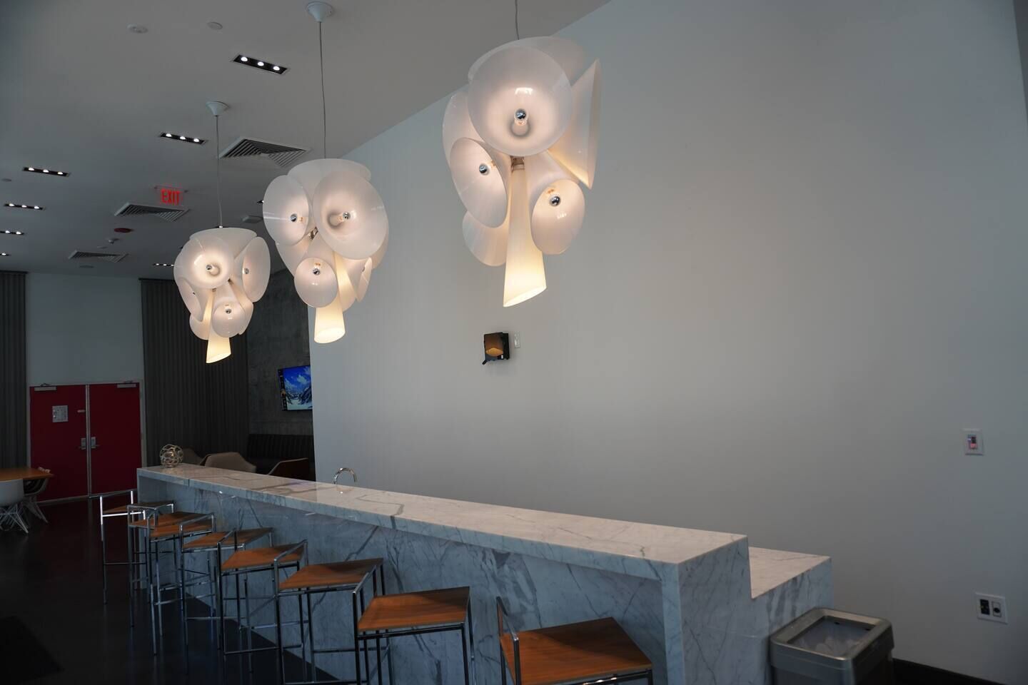 Un espace bar moderne avec des comptoirs en marbre et des tabourets de bar.