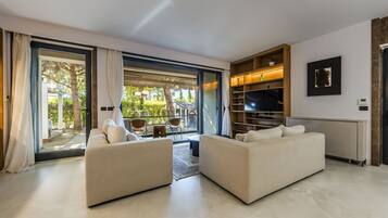 Una sala moderna con un conjunto de sofá, un televisor y una estantería.
