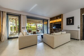 A modern living room with a sofa set, a TV, and a bookshelf. - Villa Flamingo 4BR Retreat in Valamar Residence (Sukth)