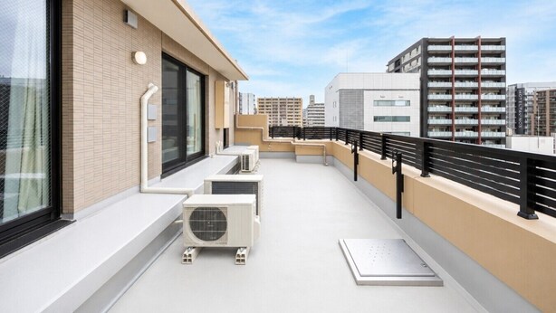 A rooftop terrace with a modern design, featuring a black railing, air conditioning units, and a clear view of the cityscape. - Three bedroom  in Japan, Taito City (Taito City)