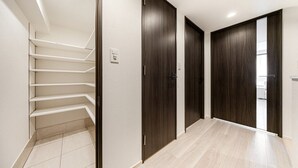 A hallway with a staircase, dark wooden doors, and light-colored tiled flooring. - Three bedroom  in Japan, Taito City (Taito City)
