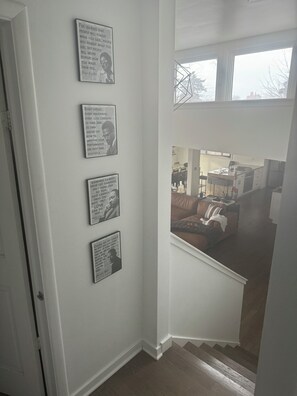 A staircase leading to a living area with a view of a kitchen and dining area. - Beautiful Mid-Century Oasis in South Shore. (Chicago)