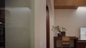 Un interior moderno con un escritorio de madera, una silla y un florero con flores.