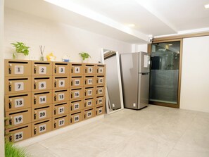 A hotel room with a minibar, a refrigerator, and a sliding glass door to the outside. - Jamjun Hostel Sukhumvit (Bangkok)