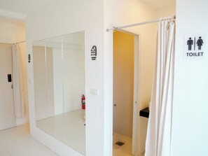 A hotel bathroom with a shower room, toilet, and a glass-enclosed area. - Jamjun Hostel Sukhumvit (Bangkok)