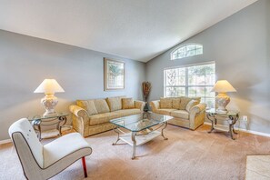 A living room with two sofas, a glass coffee table, and two lamps. - Spacious 4-bedroom house with AC in charming Davenport (Davenport)