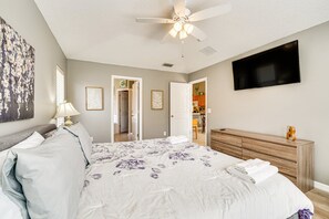 A bedroom with a bed, a ceiling fan, a TV, and a dresser. - Spacious 4-bedroom house with AC in charming Davenport (Davenport)