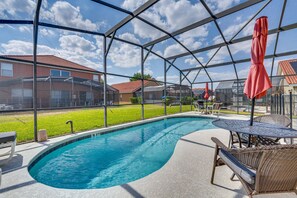 An indoor swimming pool with a clear view of the surrounding area, including a covered patio with seating and umbrellas. - Spacious 4-bedroom house with AC in charming Davenport (Davenport)