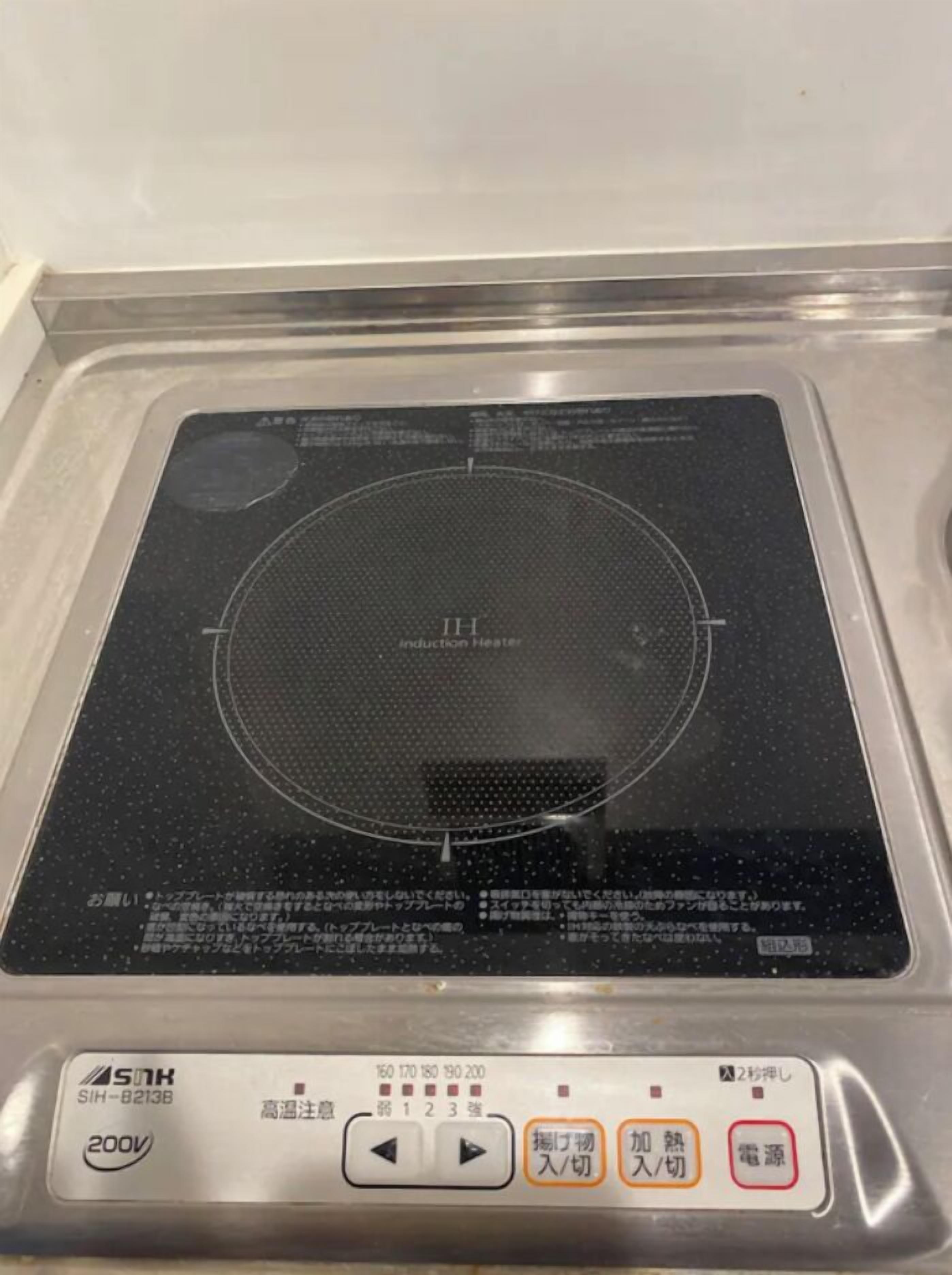 Una cucina con piano cottura a induzione e un pannello di controllo con pulsanti per diverse funzioni.