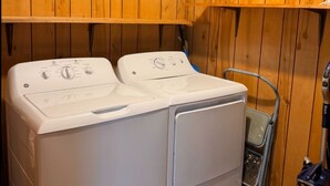 Een wasserette met twee gestapelde wasmachines en een stofzuiger.