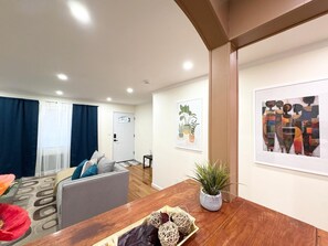 A living room with a sofa, a wooden coffee table, and a potted plant.