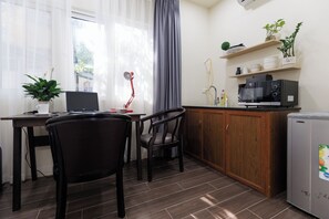 A compact kitchen with a microwave, refrigerator, and a small dining area with a chair and table. -  Peaceful luxury Stay by Hanoi Old Quarter ,Opera House & Hoan Kiem Lake (Hà Nội)