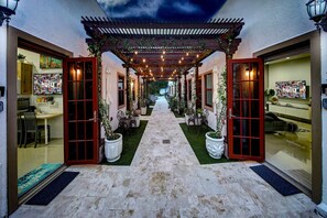 A covered outdoor corridor with a stone floor, potted plants, and a view into the interior. - Stunning Classy Retreat - 5★ DT Location -♛Hot Tub (Fort Lauderdale)