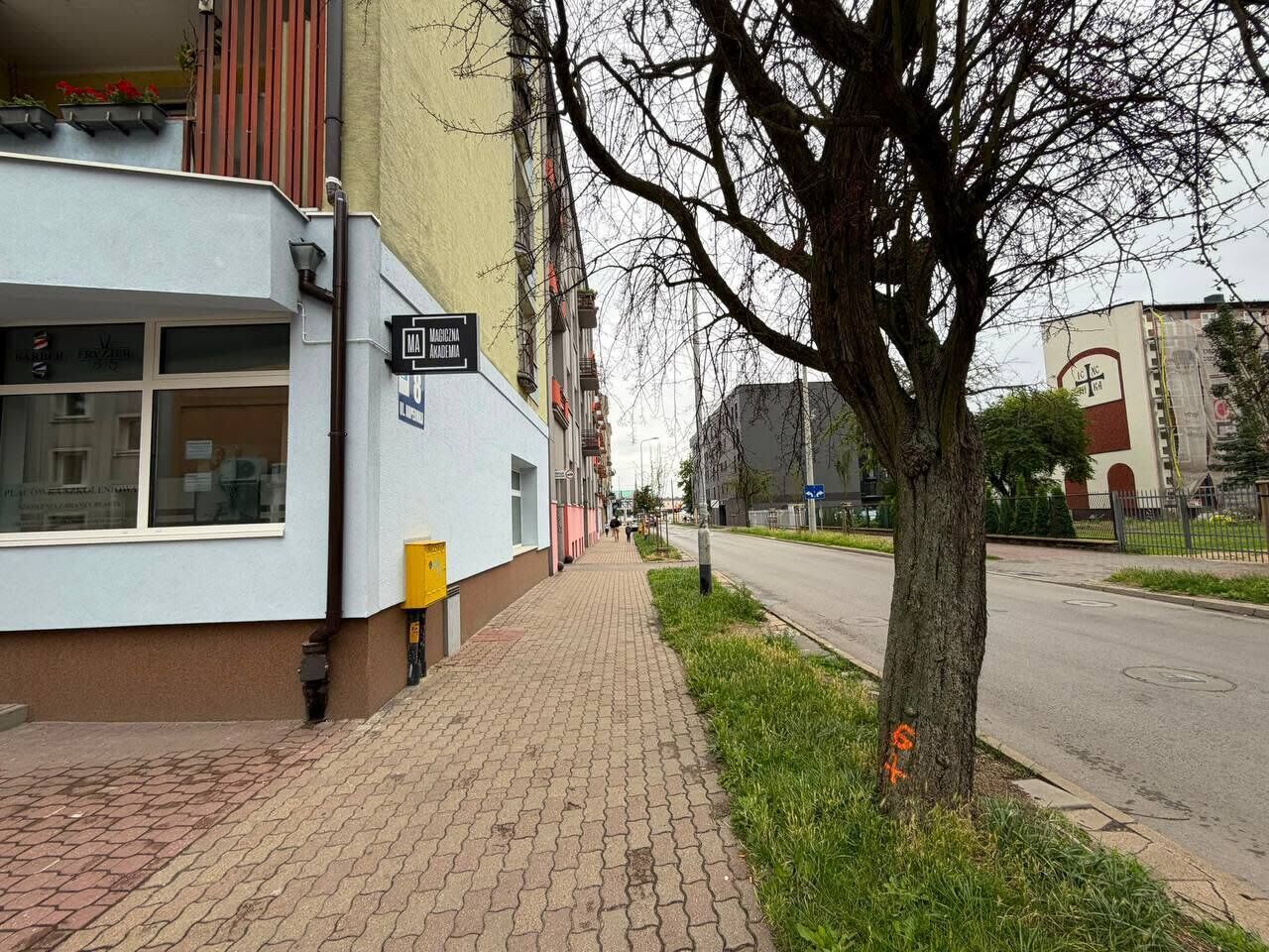 A sidewalk adjacent to a building with a sign that reads 'MAJESTY.'