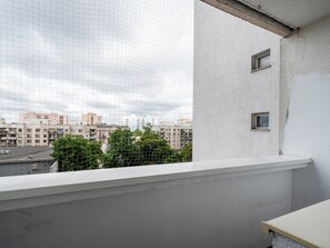 A balcony with a view of a cityscape, including buildings and a road. - Piotrkowska Spacious Apartment (Łódź)