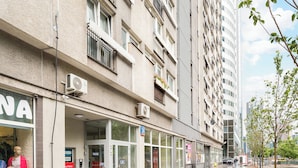 A multi-story building with a storefront on the ground floor, large windows, and a pedestrian walkway. - Park Mirowski Central Apartment (Warszawa)