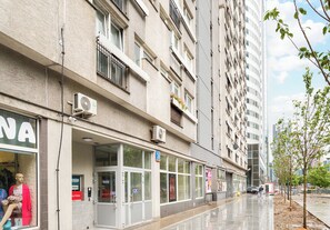 A multi-story building with a storefront on the ground floor, large windows, and a pedestrian walkway. - Park Mirowski Central Apartment (Warszawa)