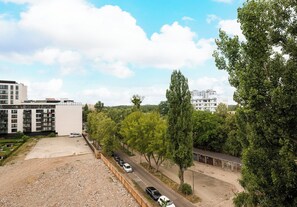 Een meerlaags gebouw met een parkeerplaats, bomen en een heldere lucht.