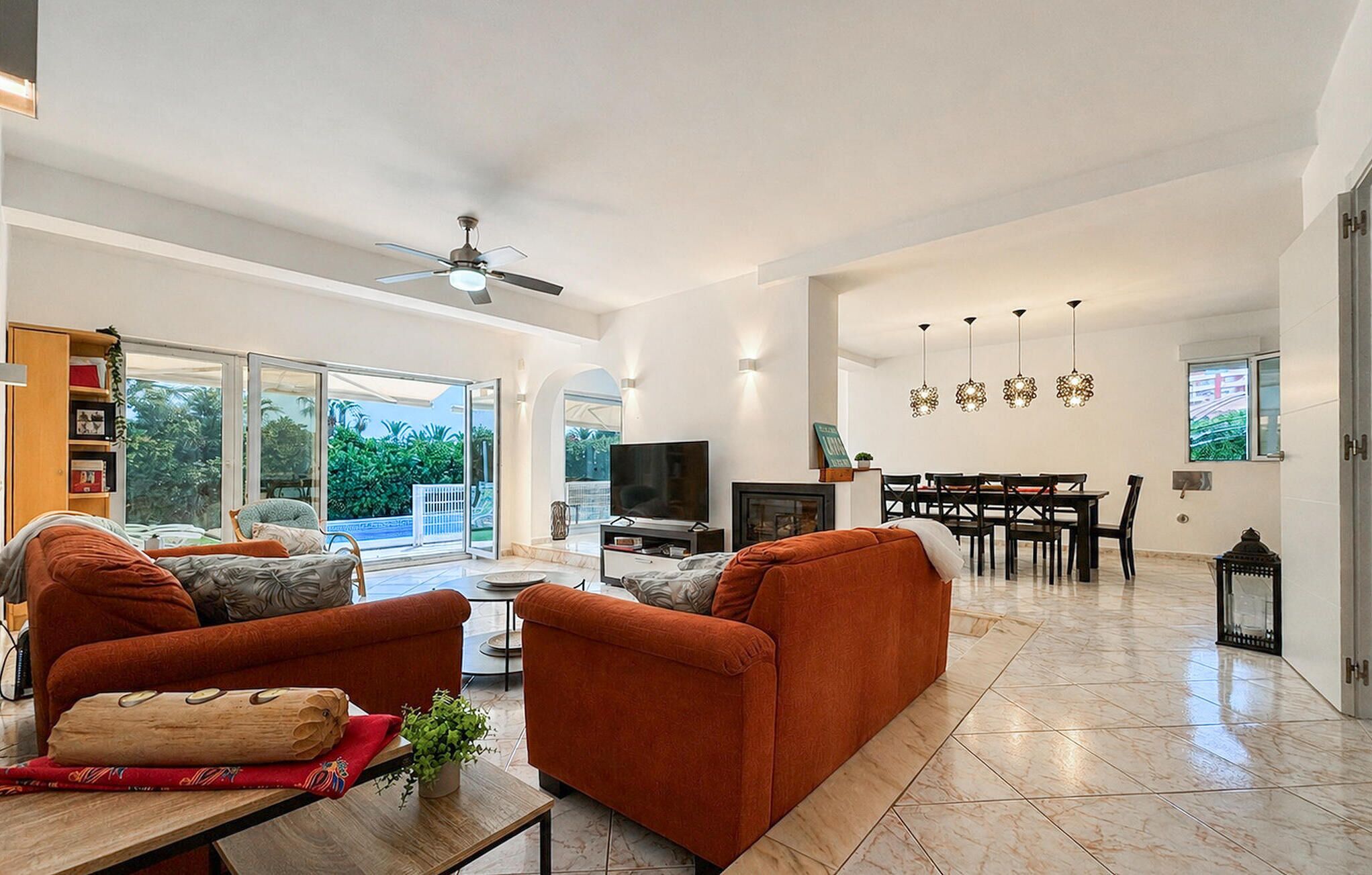 A spacious living area with a sofa, TV, and dining table.