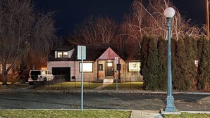 Een woonhuis met garage, oprit en straatverlichting.