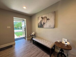 Ein Flur mit einer Bank, einem kleinen Tisch mit einer Kerze und einem gerahmten Bild an der Wand.
