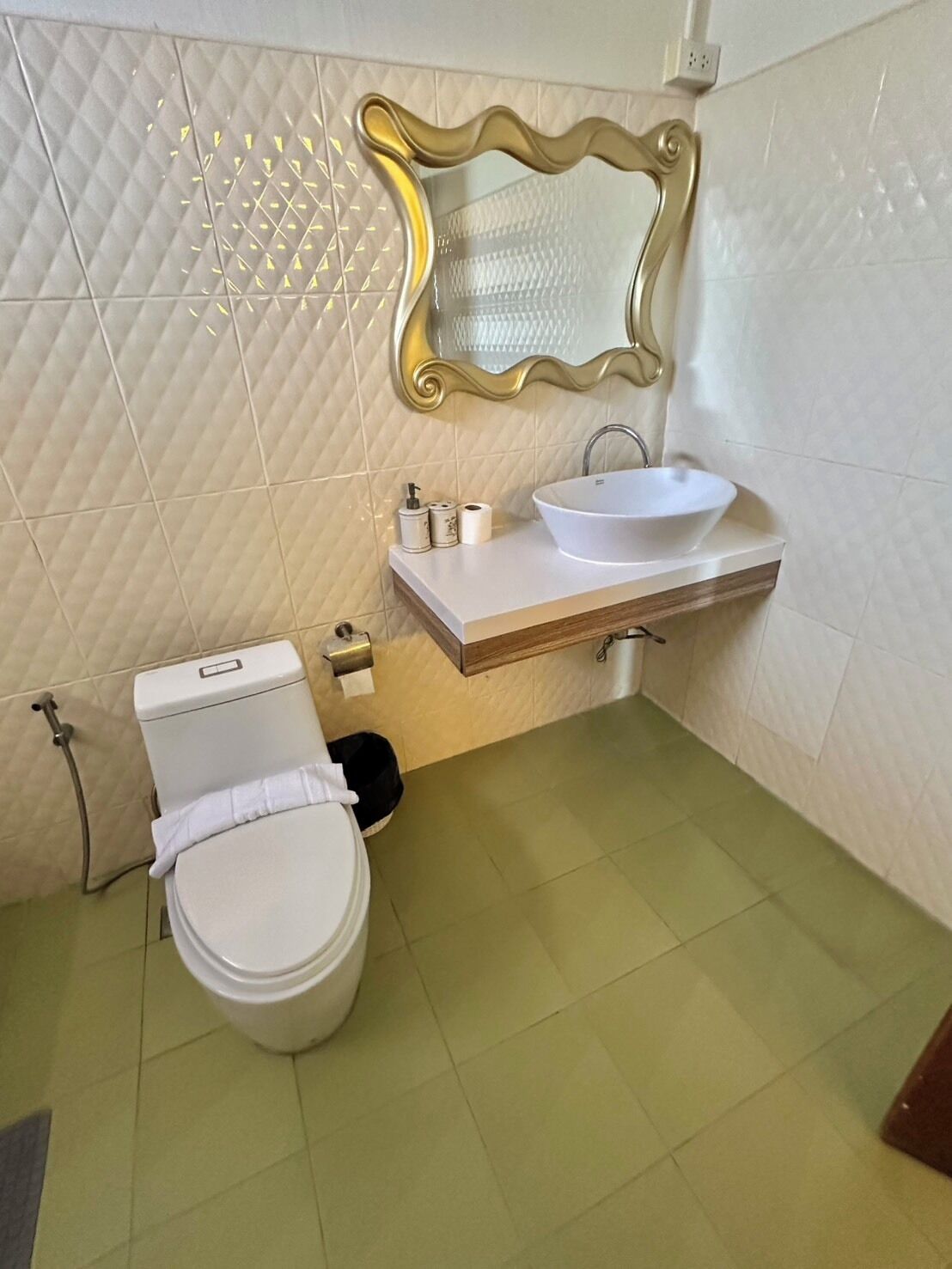 Kylpyhuone, jossa on wc, pesuallas ja peili.