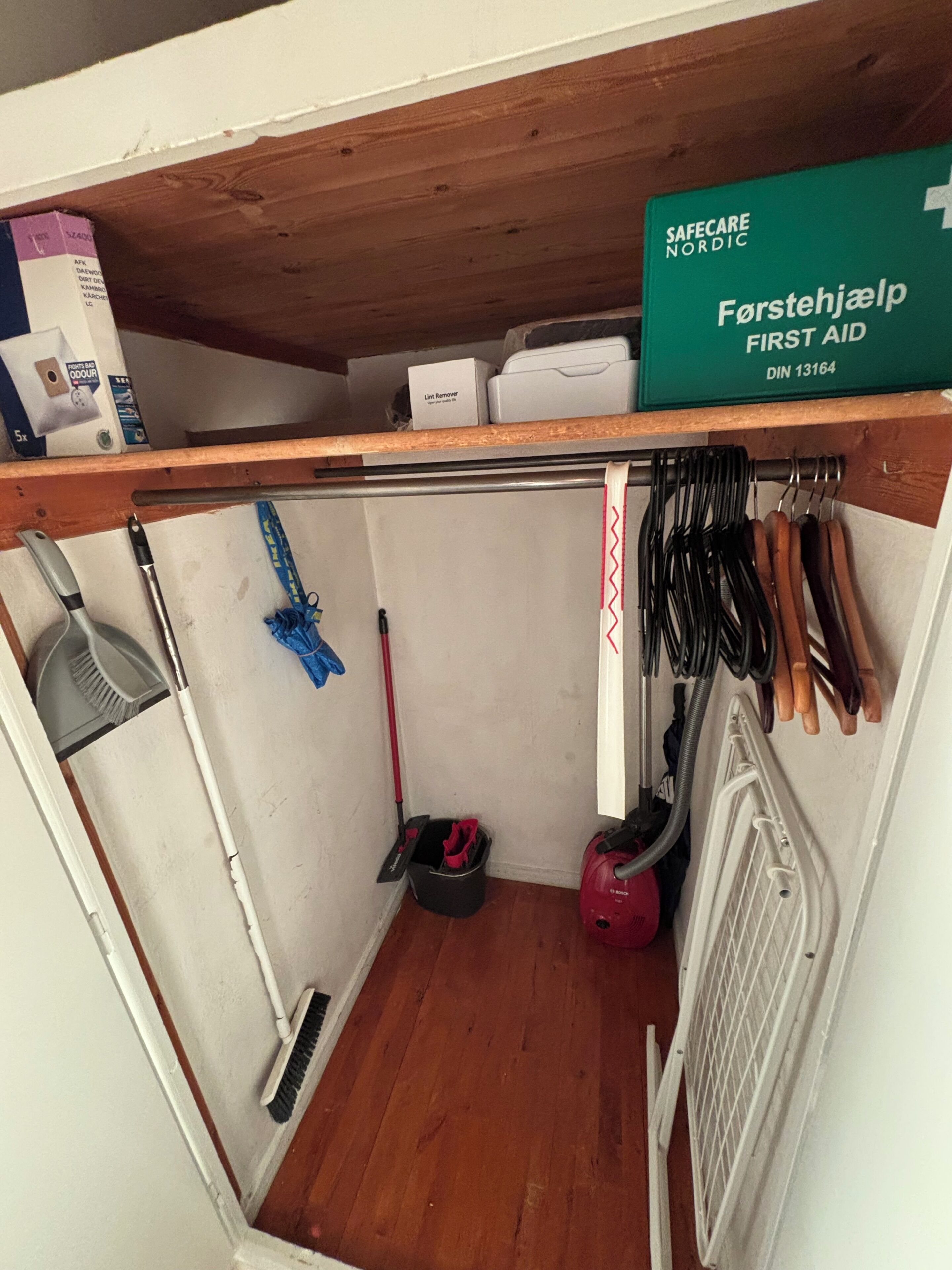 A storage area with cleaning tools, a first aid kit, and a radiator.