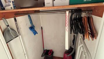 A storage area with cleaning tools, a first aid kit, and a radiator.